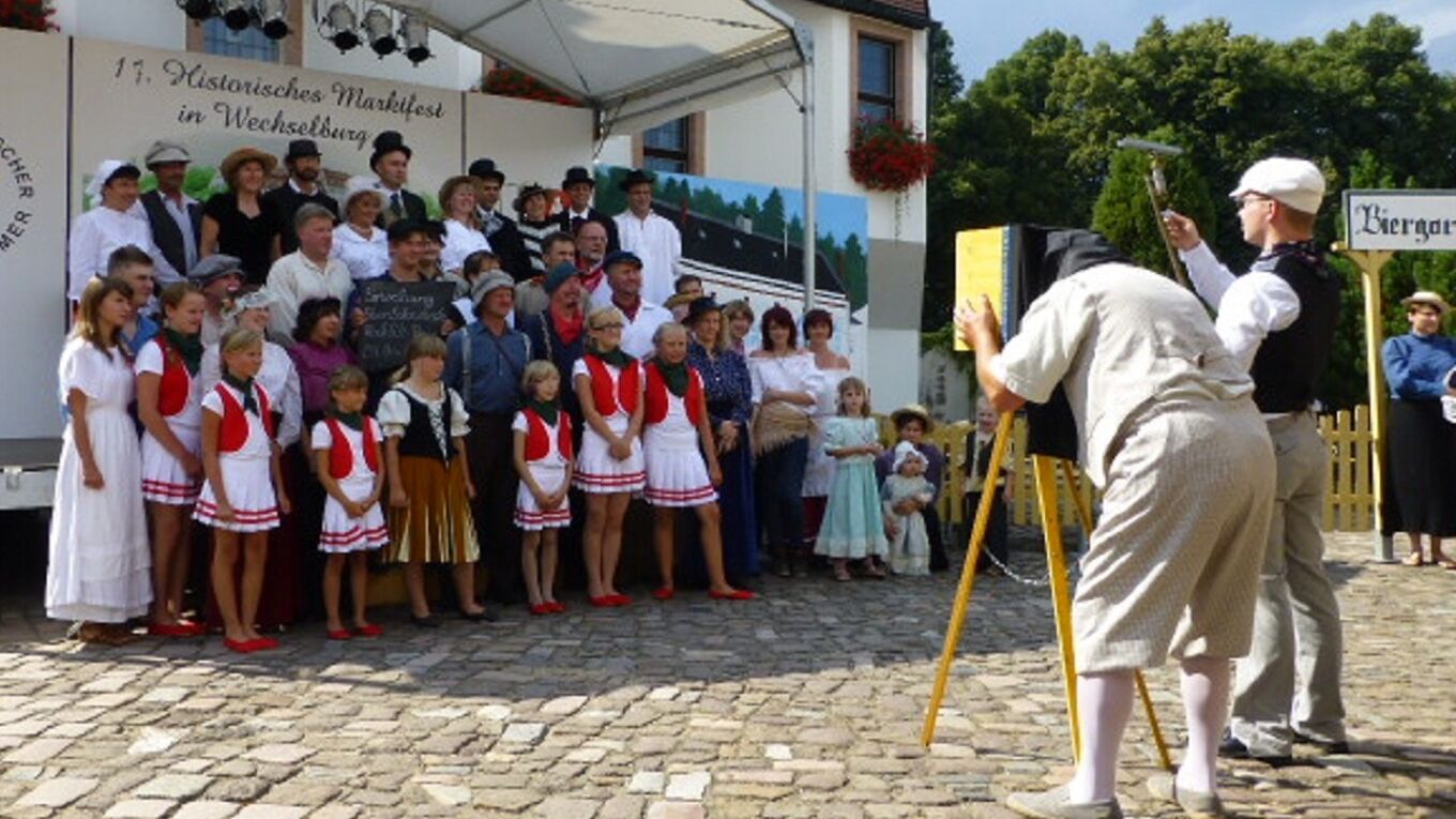17. Historisches Marktfest in Wechselburg, Fotograf mit Plattenkamera fotografiert Kostümierte.